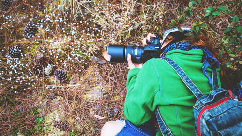 Woman photographing plants at forest