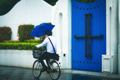 Man riding bicycle on road during rainy season