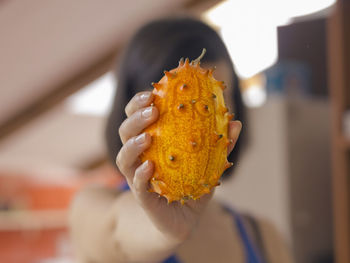 Close-up of hand holding kiwano fruit