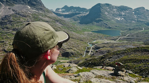 Portrait of woman on rock against mountains