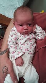 Portrait of cute baby girl lying on bed