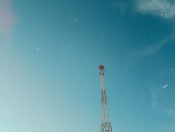 Low angle view of communications tower against blue sky