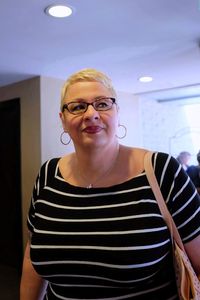 Smiling mature woman standing against wall