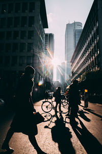 People on street amidst buildings in city