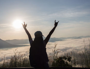 Rear view of silhouette person standing against sky during sunset