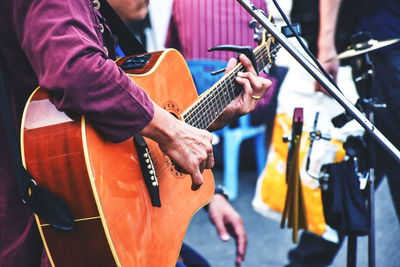 Cropped image of artist playing guitar at music concert