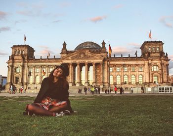 Portrait of young woman sitting against the reichstag