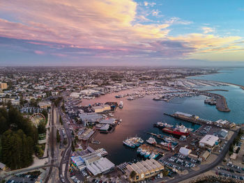 High angle view of cityscape by sea against sky during sunset