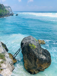 Rock formation in sea against sky