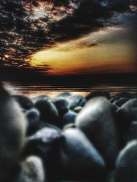 Surface level of beach against sky during sunset