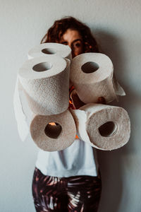 Portrait of woman holding toilet paper rolls