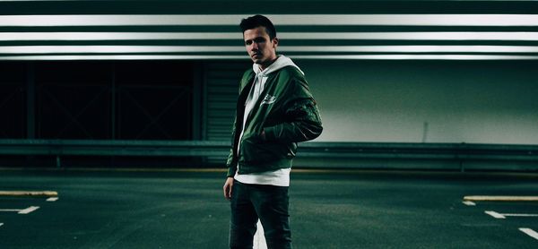 Full length portrait of young man standing at night