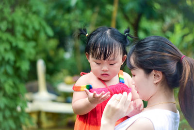 Close-up of girl blowing bubbles while standing outdoors