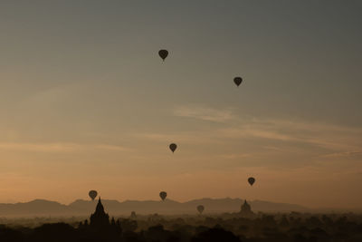 Low angle view of hot air balloons against sky during sunset