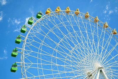 Low angle view of ferris wheel against blue sky