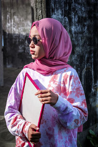 Girl looking away while holding umbrella