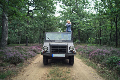 Woman standing in jeep at forest