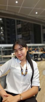 Side view of young woman standing at home