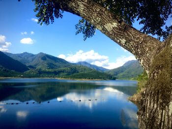 Scenic view of lake and mountains against blue sky