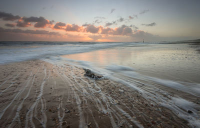 Scenic view of beach against sky during sunset