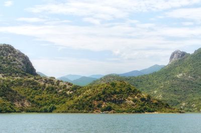 Scenic view of mountains by sea against sky