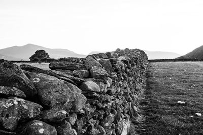 Scenic view of rocks on field against clear sky