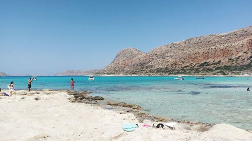 Scenic view of beach against clear blue sky