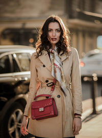 Portrait of fashionable woman standing against building in city