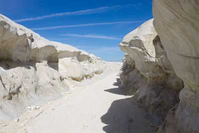 Rock formations on beach against sky