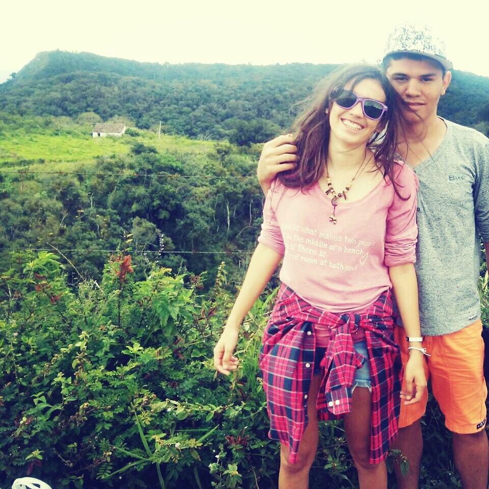 lifestyles, casual clothing, young adult, leisure activity, person, young women, standing, smiling, looking at camera, portrait, three quarter length, front view, happiness, tree, day, mountain, nature