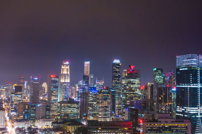 Illuminated buildings in city against sky at night