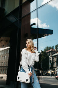 Woman standing on mobile phone in city