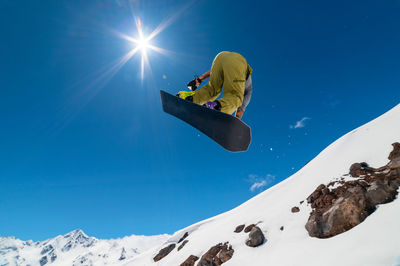 Low angle view of man skiing on snow covered mountain