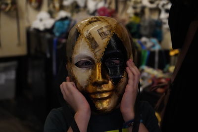 Portrait of boy wearing mask in store