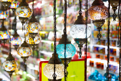 Close-up of illuminated lanterns hanging in store for sale
