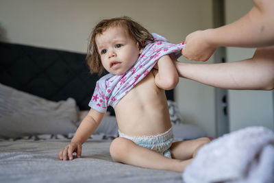 Portrait of cute baby boy lying on bed at home