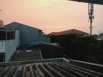 Buildings by swimming pool against sky during sunset