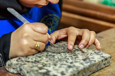 Close-up of craftsperson working on table