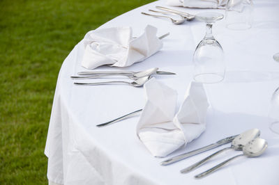 High angle view of cutlery and napkins on dining table at lawn