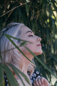 Portrait of woman wearing red leaf outdoors