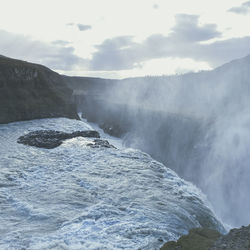 Scenic view of waterfall against sky