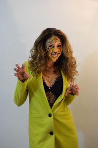 Portrait of smiling young woman with face paint against white background