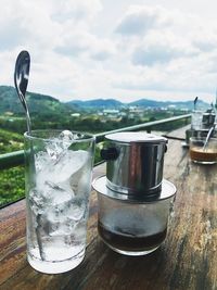 Close-up of drink in glass on table at restaurant against sky