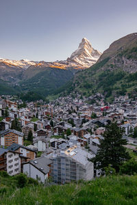 Townscape by mountains against clear sky