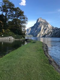 Scenic view of lake by mountains against sky