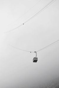 Low angle view of overhead cable car against clear sky