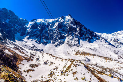 Scenic view of snowcapped mountains against clear blue sky