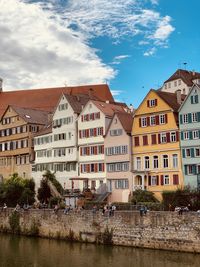 Buildings by river against sky