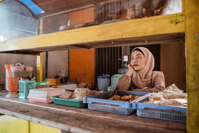 Portrait of young woman standing in store