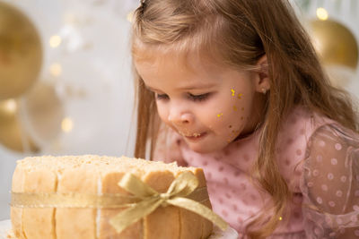 Cute girl eating birthday cake at home